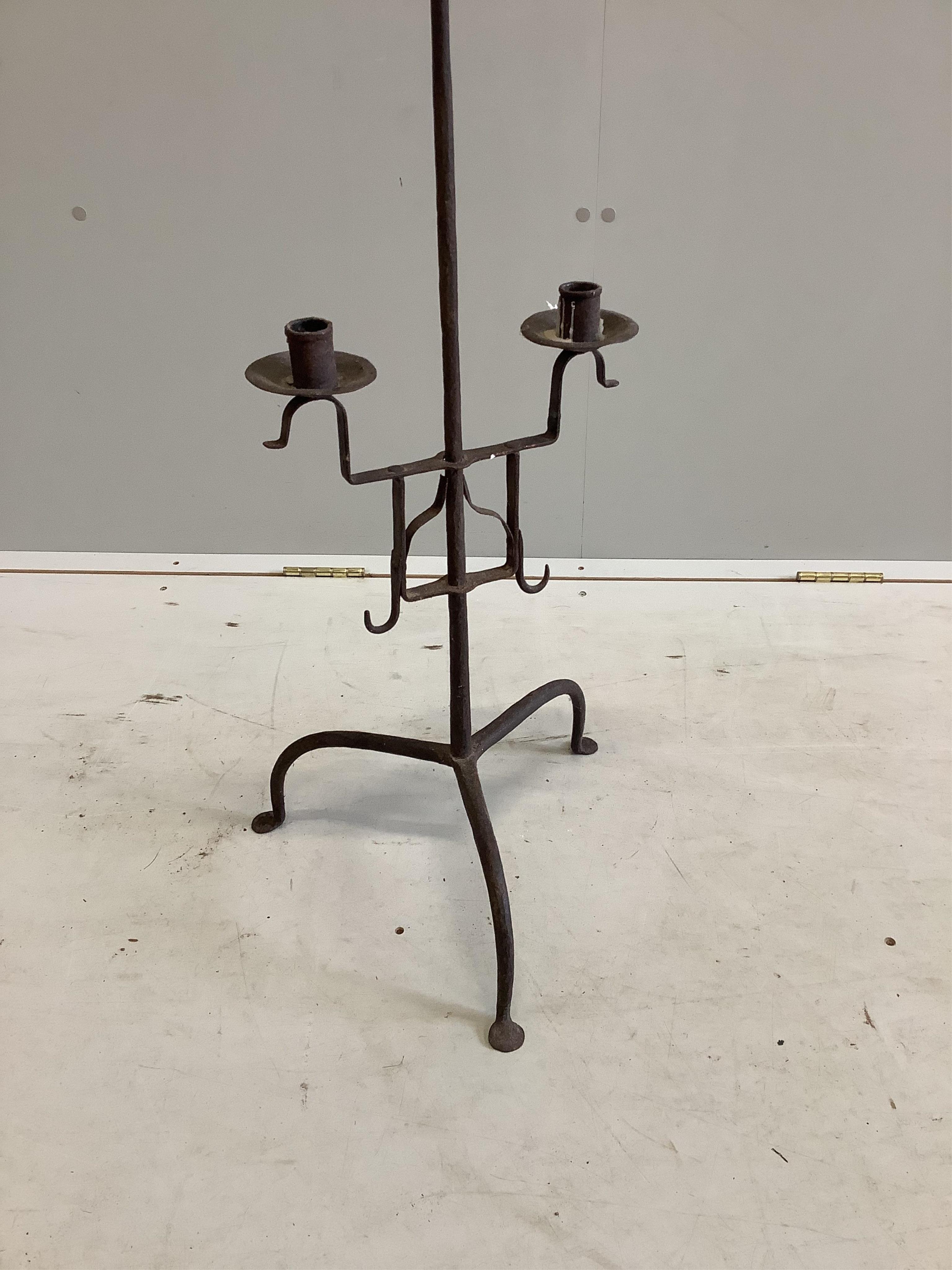 A 17th century wrought iron tripod candle stand, height 134cm. Condition - fair